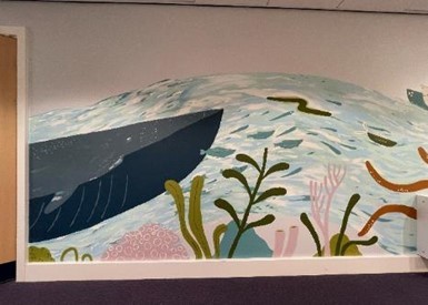 Part of the mural showing an under the ocean theme including a whale and seaweed at Severnfields Health Village