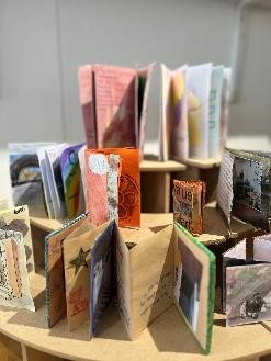 Miniture books made by attendees of the Wellbeing Art Group on display.