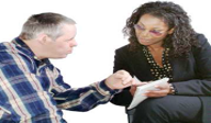 A man looking at a notepad held by a woman.png