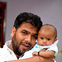 head and shoulders picture of a man holding a baby, their heads touching.jpg
