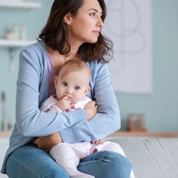 Woman looking into distance holding child on her lap.jpg