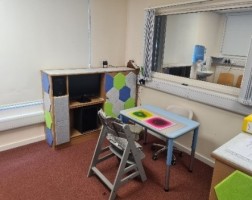 A table and chair inside the audiology room at The Coach House