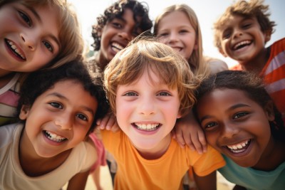 Children lean in smiling towards the camera