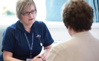 Female staff member speaking to an older woman