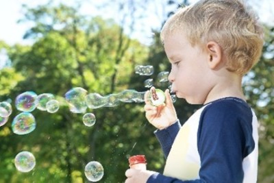 Young boy blowing bubbles