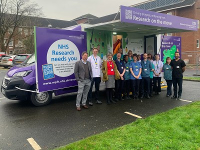 Image shows colleagues standing in front of the Research Bus.
