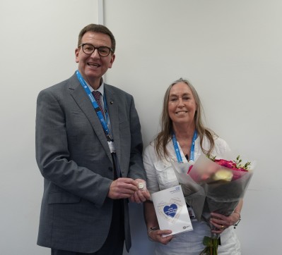 Jane Curtis receiving flowers and a long service card from Dr Ian Turner