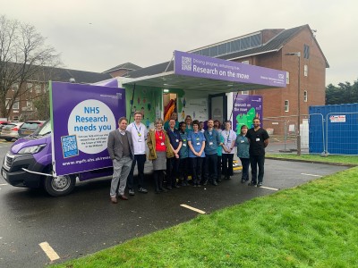 Image shows colleagues standing in front of the Research Bus.