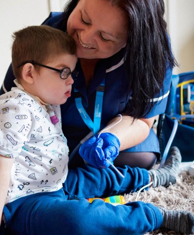 A nurse working with a young boy who has a disability.
