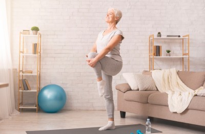 A woman stretches her legs in a living room.