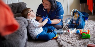 A nurse speaks with a child whilst providing care