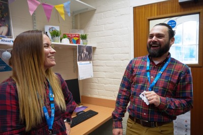 A man and a woman talking in an office.