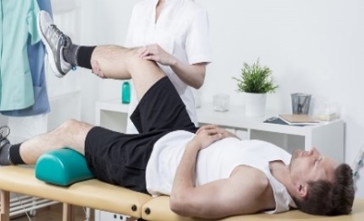 A man receiving physiotherapy treatment on his legs